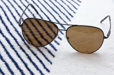 Aviator sunglasses on beach towel
